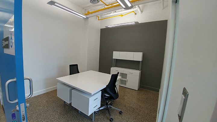 Bureau privé avec porte bleue, bureau blanc et fauteuil de travail